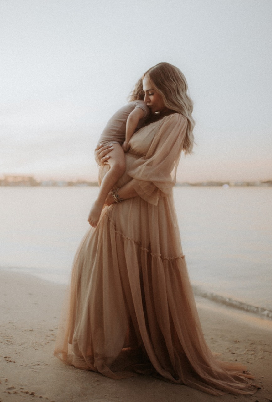Taliya holding one of her children by the water